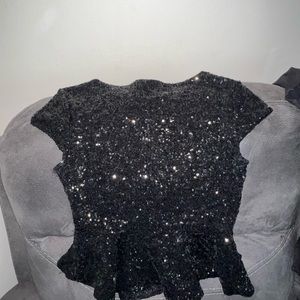 Beautiful black sequined blouse can be paired with a skirt or denim jeans. Bebe